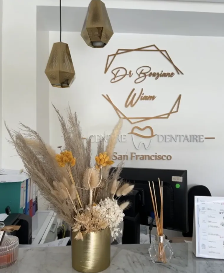 Comptoir d'accueil du Centre Dentaire San Francisco, avec le logo mural du cabinet